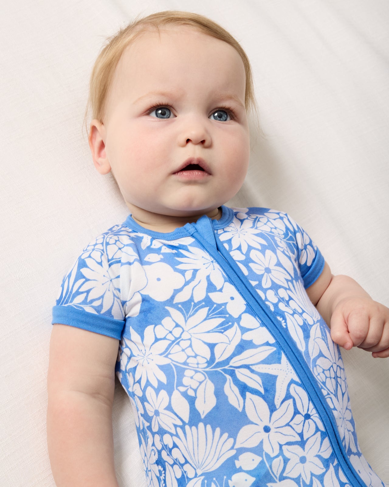 Close up of baby wearing the Azure Garden Shorty Zippy