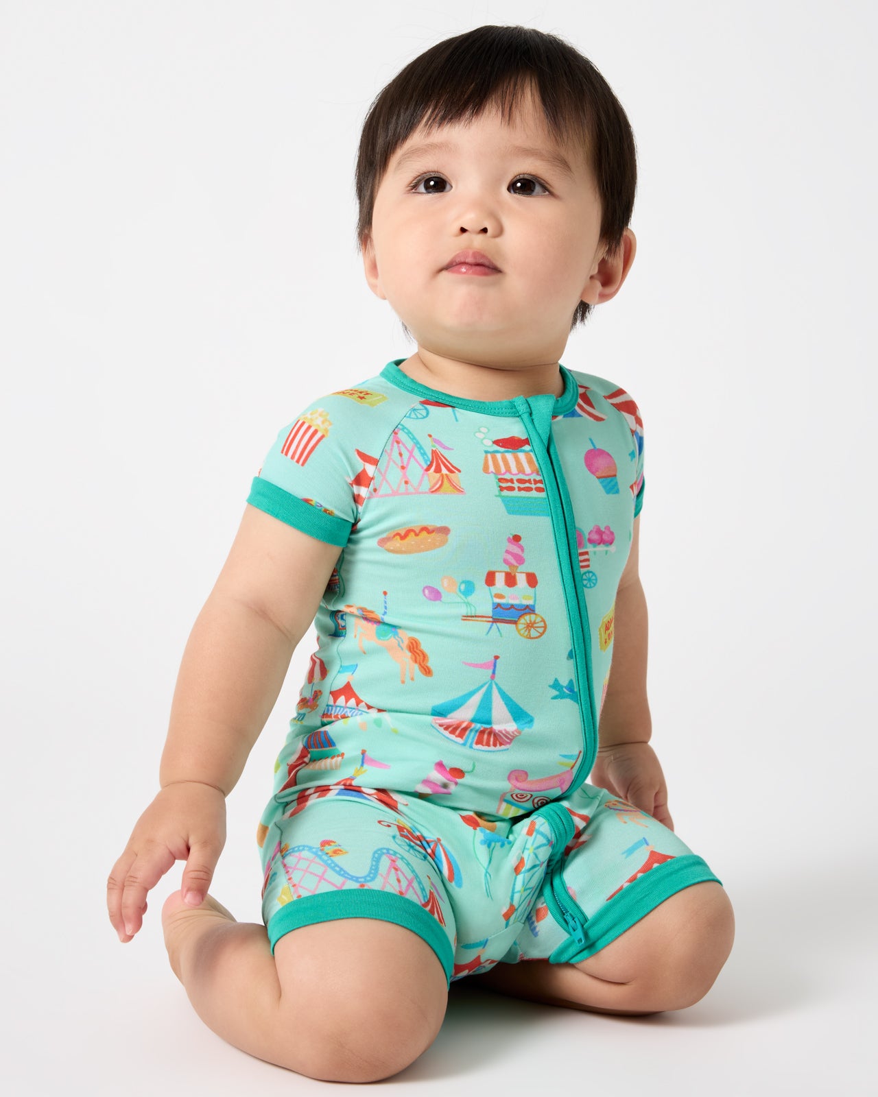 Sitting baby wearing the Fizzy Fair Shorty Zippy