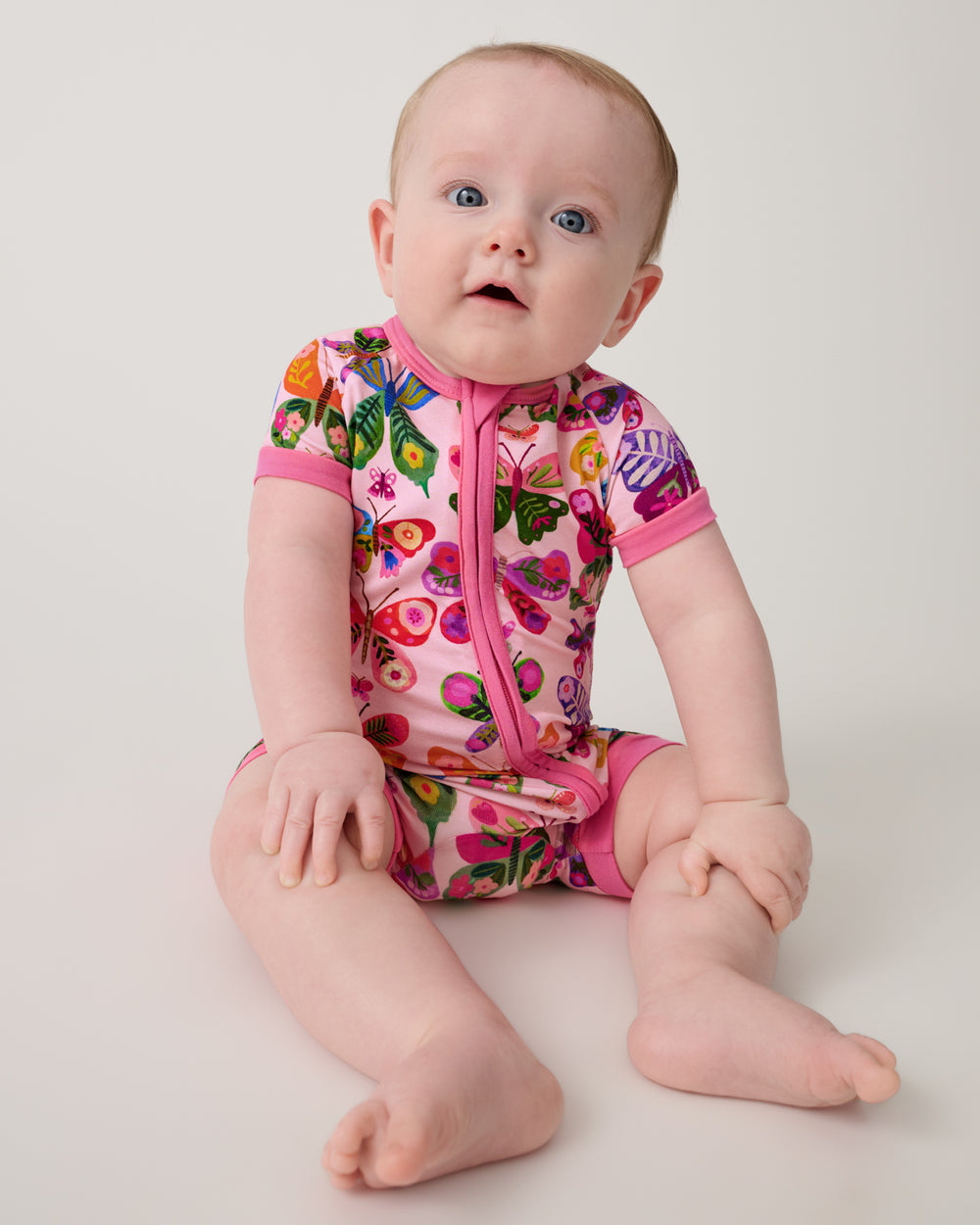 Sitting baby wearing the Flutter Garden Shorty Zippy
