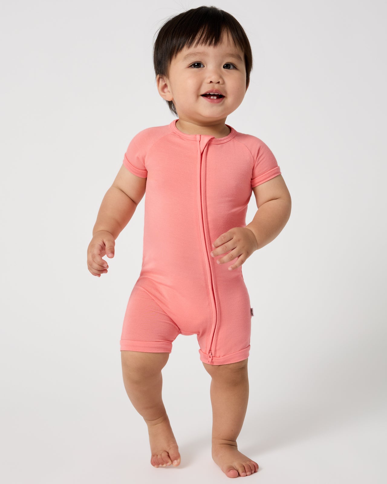 Walking baby wearing the Sweet Papaya Shorty Zippy
