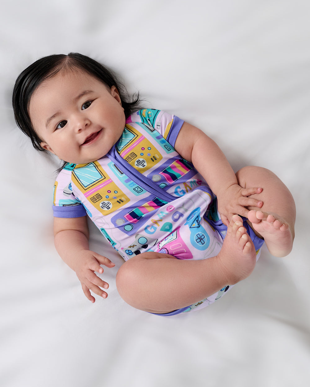 Aerial view of newborn wearing the Purple Game On Shorty Zippy
