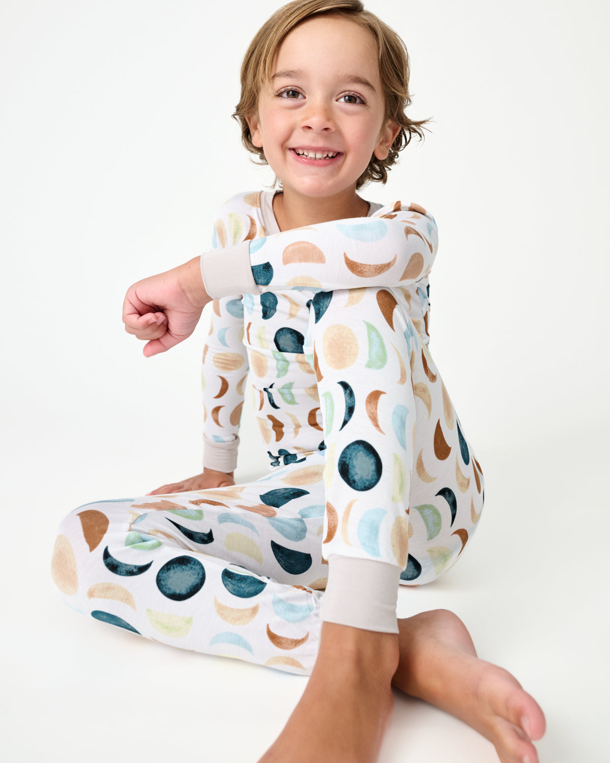 Sitting child wearing the Luna Neutral Two-Piece Pajama Set