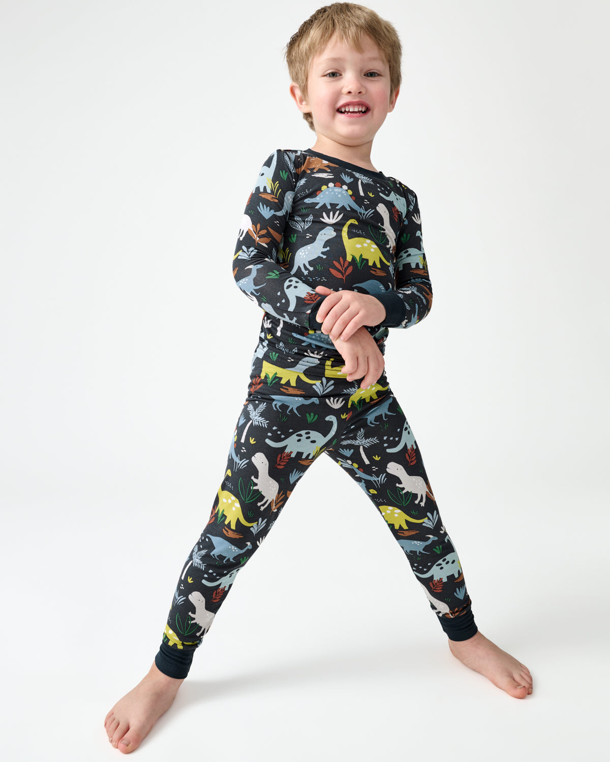Boy wearing the Navy Jurassic Jungle Dinosaur Print Two-Piece Pajama Set