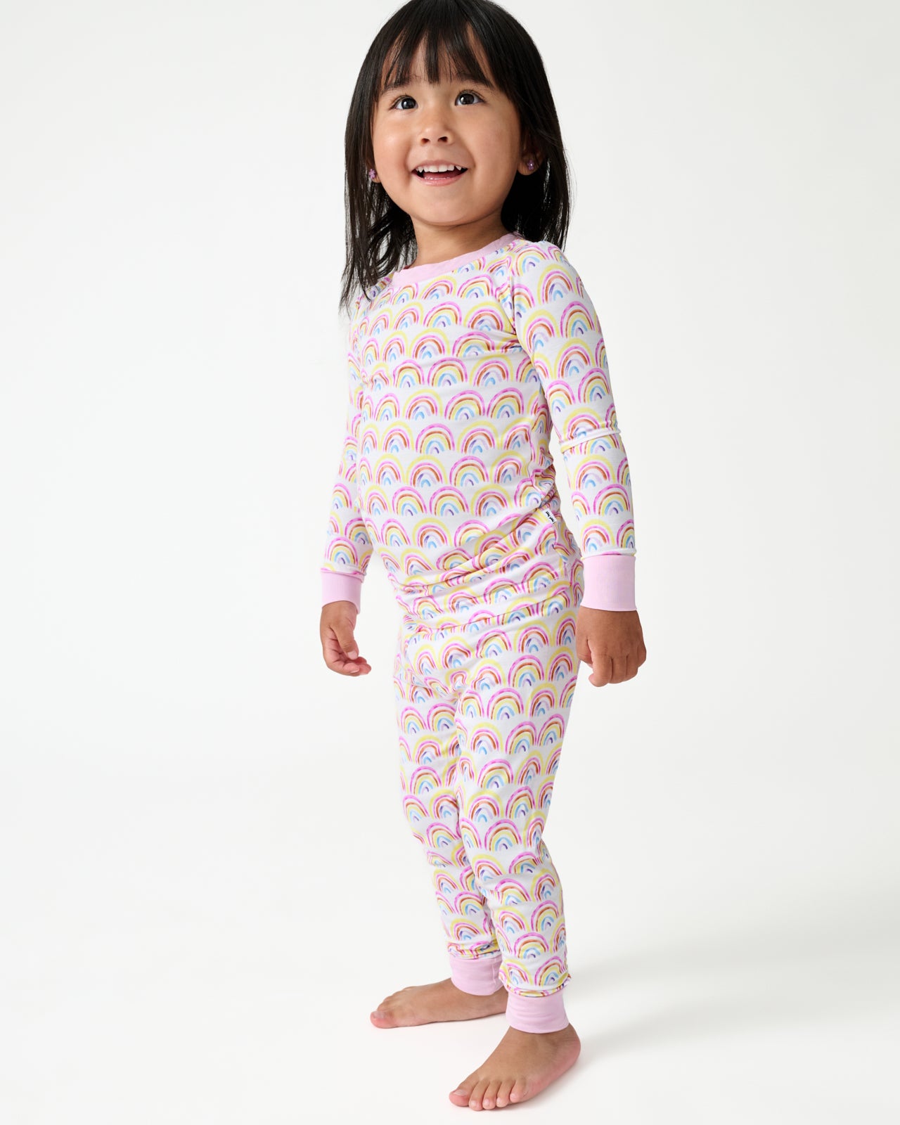 Standing girl wearing the Pastel Rainbows Two-Piece Pajama Set