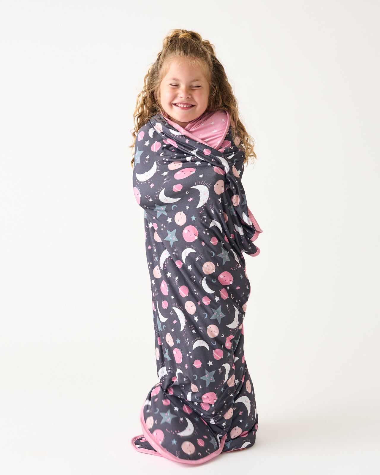 Standing girl wrapped in the Pink To the Moon & Back Large Cloud Blanket®