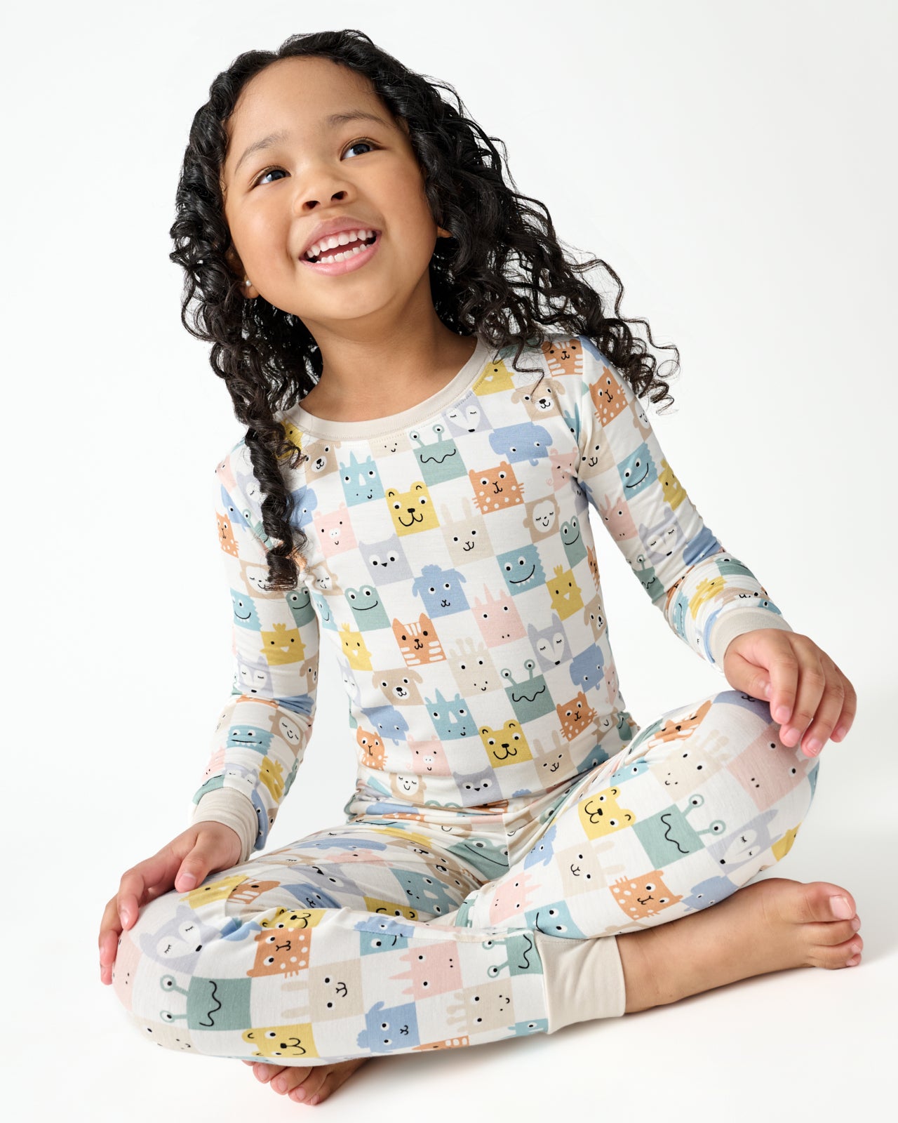 Sitting girl wearing the Check Mates Two-Piece Pajama Set