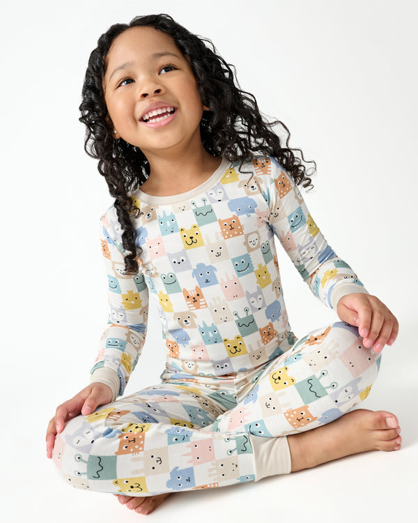 Sitting girl wearing the Check Mates Two-Piece Pajama Set