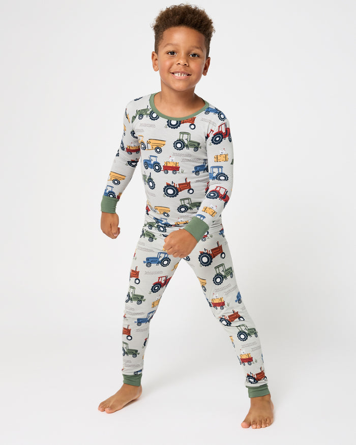 Standing boy wearing the Tractor Tales Two-Piece Pajama Set