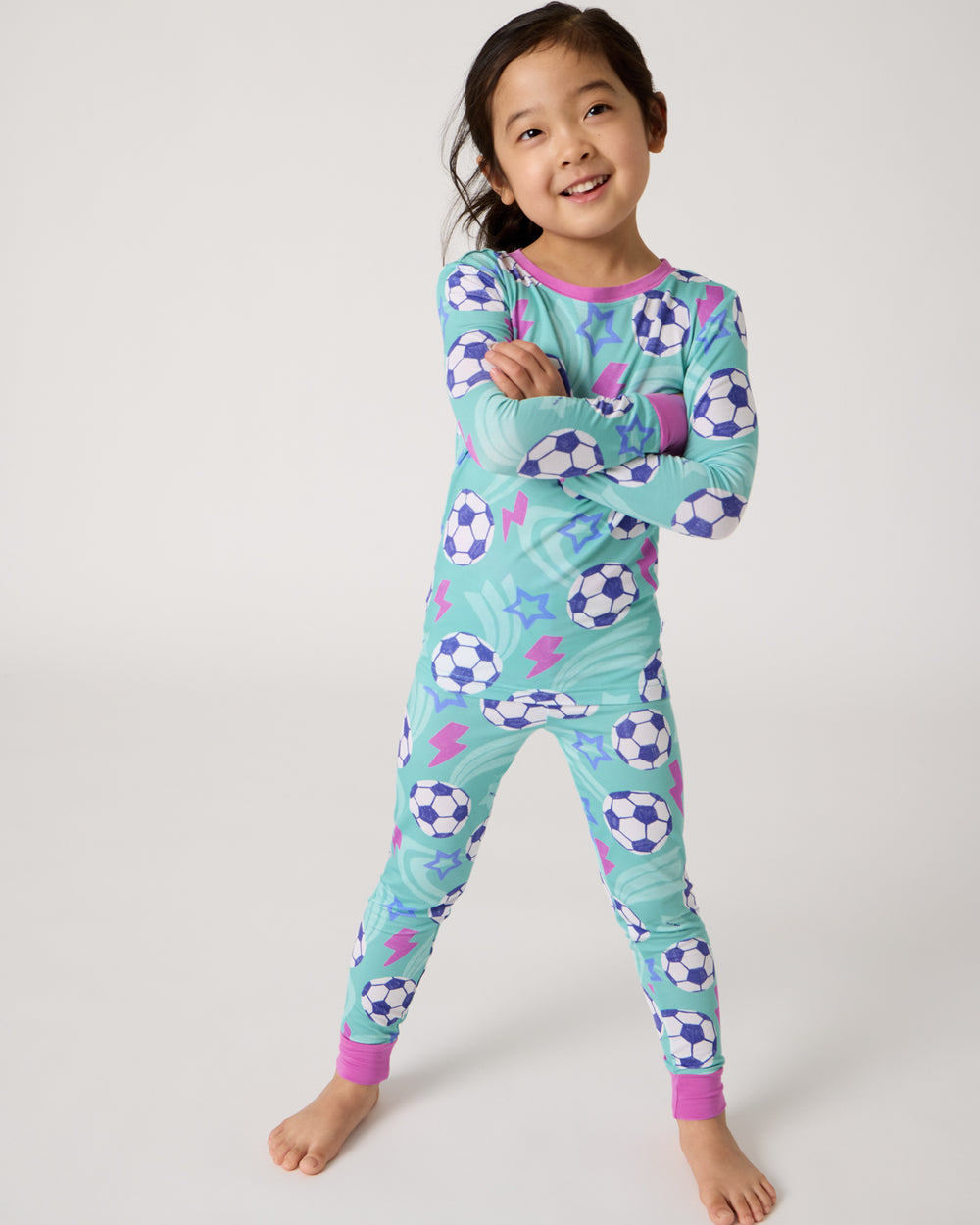 Standing girl wearing the Aqua Soccer Stars Two-Piece Pajama Set