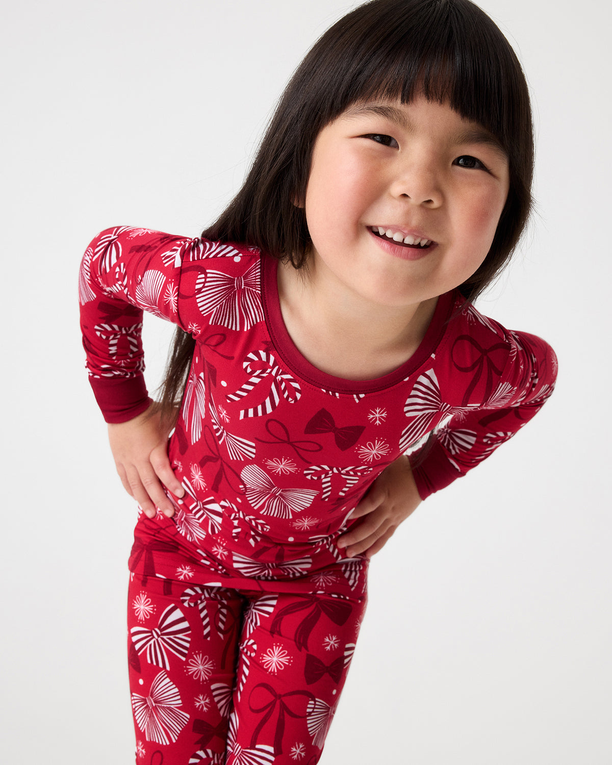 Close up of girl wearing the Holiday Bows Two-Piece Pajama Set