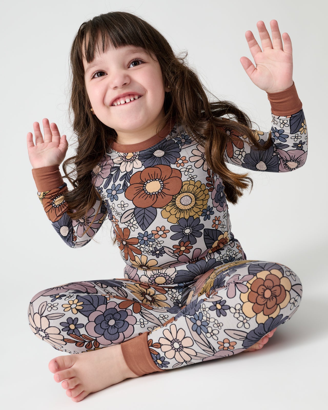 Sitting girl wearing the Wildwood Floral Two-Piece Pajama Set