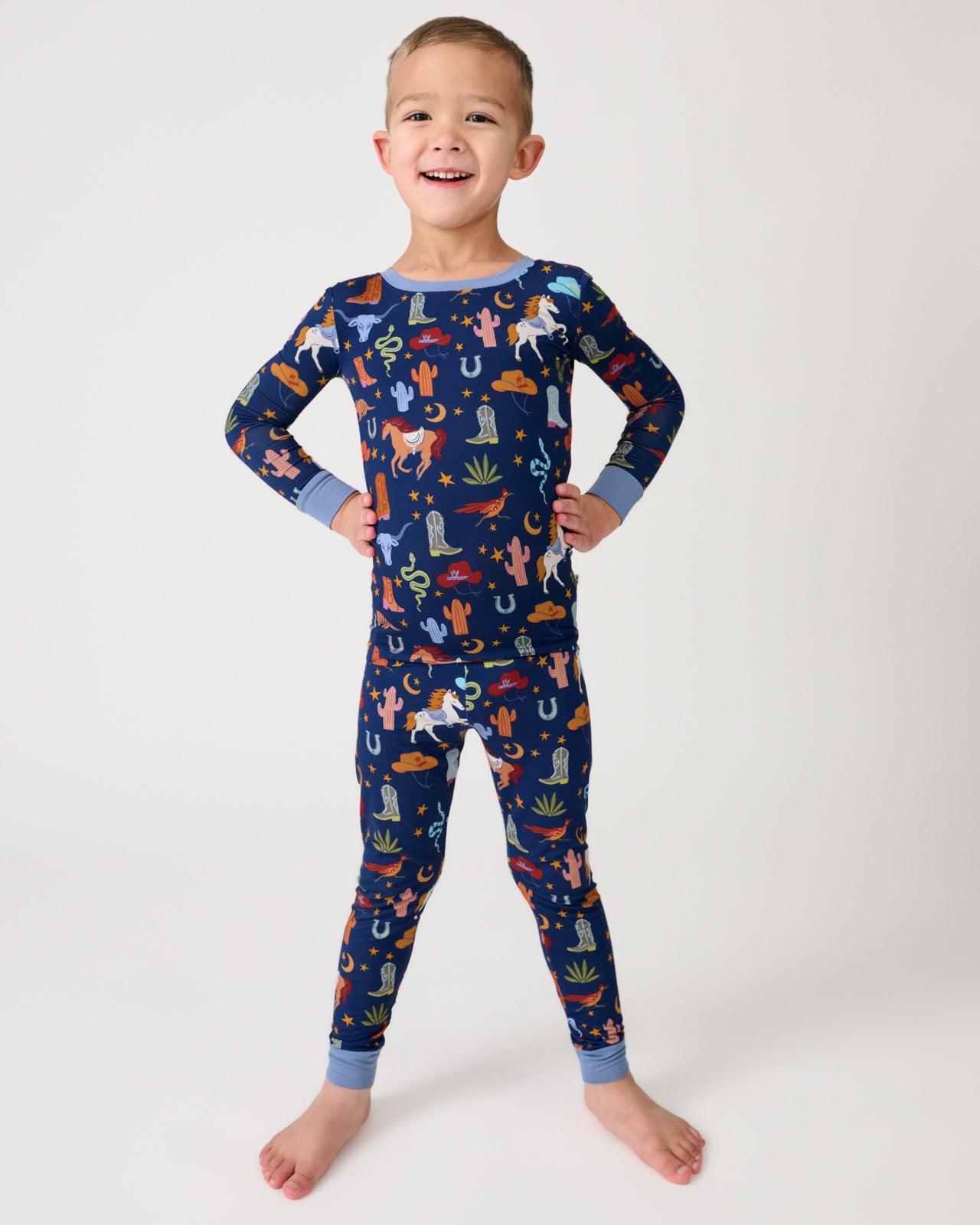 Standing boy wearing the Blue Rancher Roundup Two-Piece Pajama Set