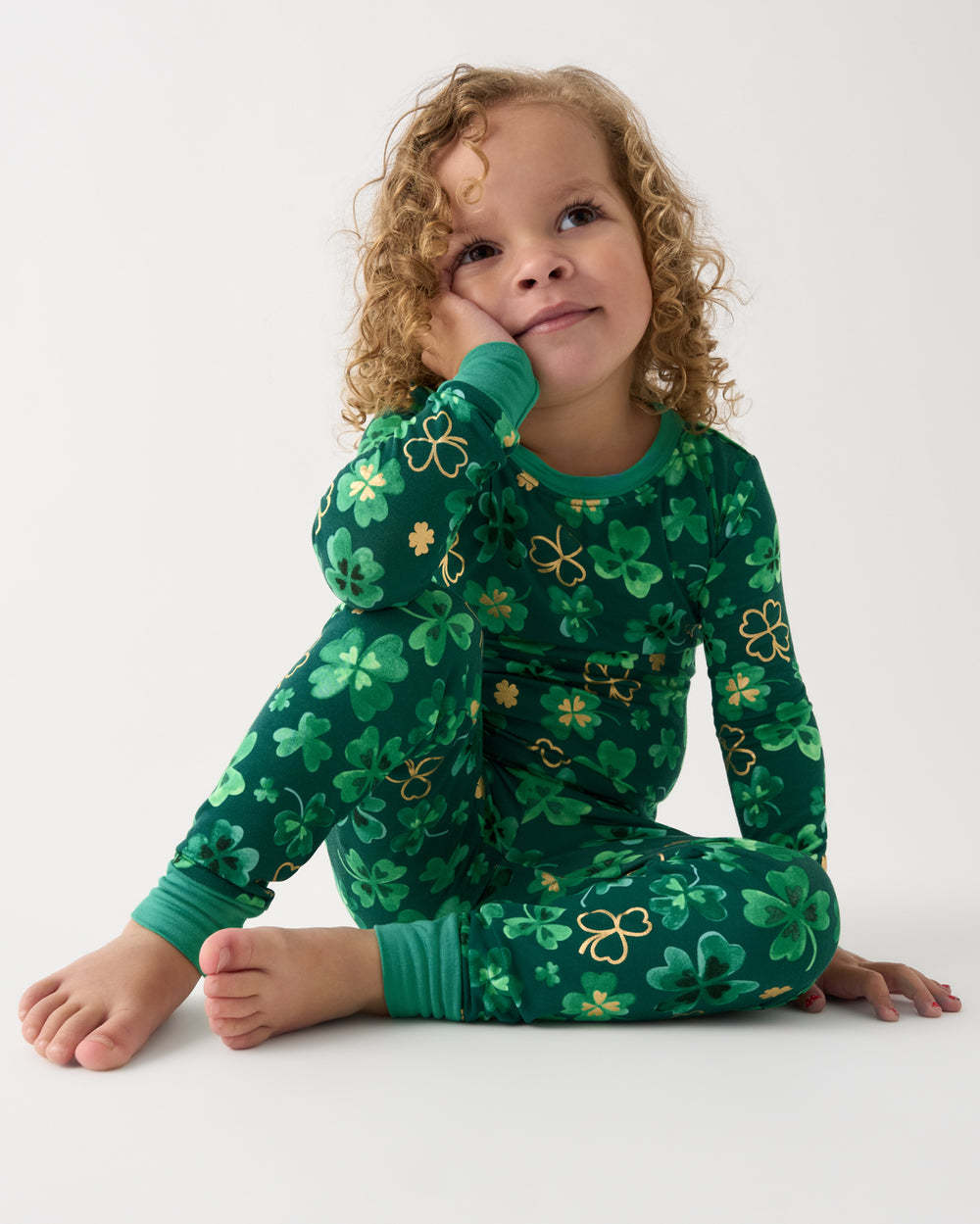 Sitting girl wearing the Clover Cuties Two-Piece Pajama Set