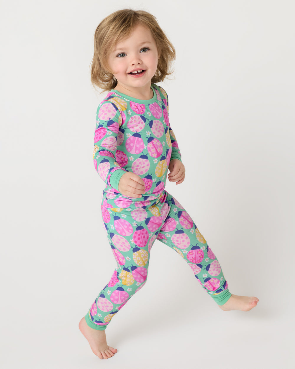 Child in motion wearing the Ladybug Meadow Two-Piece Pajama Set