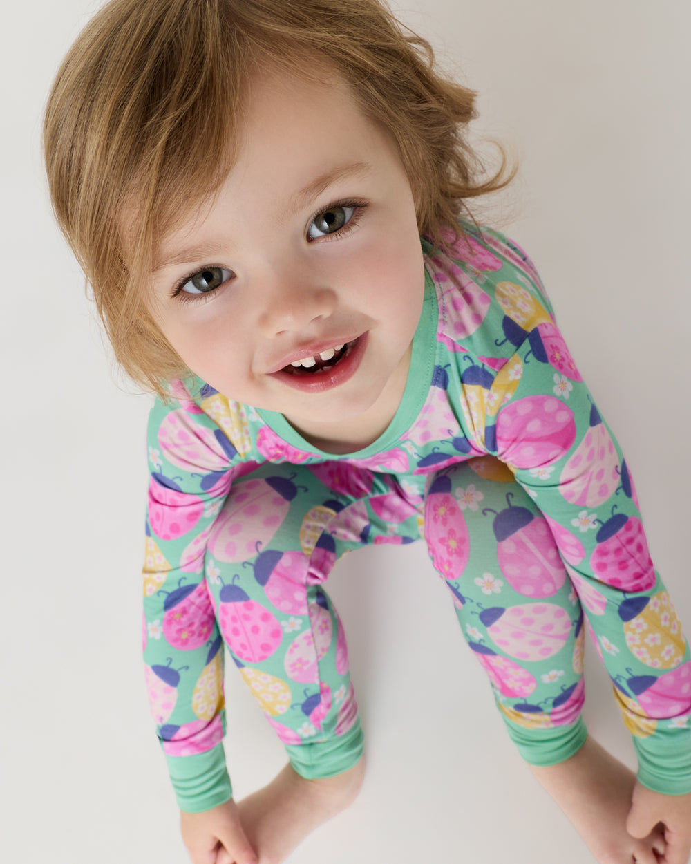 Close up of sitting girl wearing the Ladybug Meadow Two-Piece Pajama Set