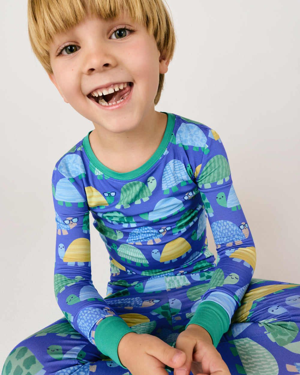Sitting boy wearing the Shell Parade Two-Piece Pajama Set