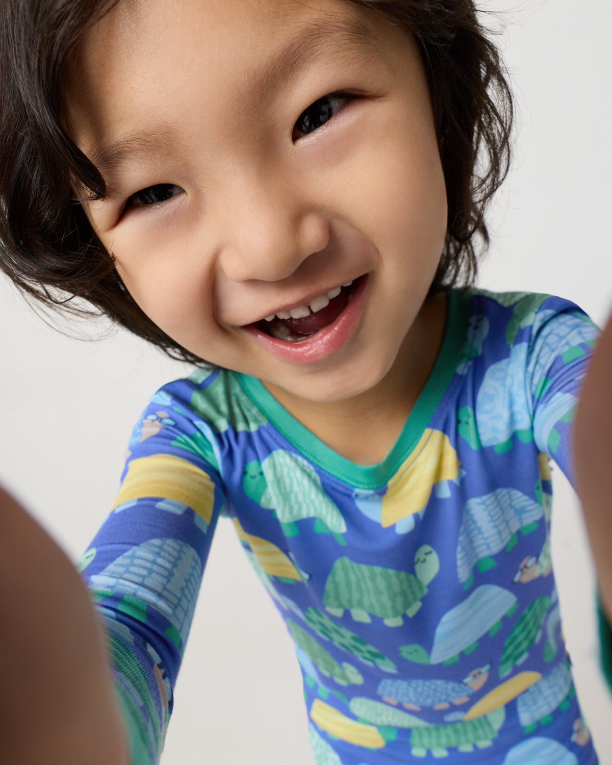 Boy wearing the Shell Parade Two-Piece Pajama Set holding the camera