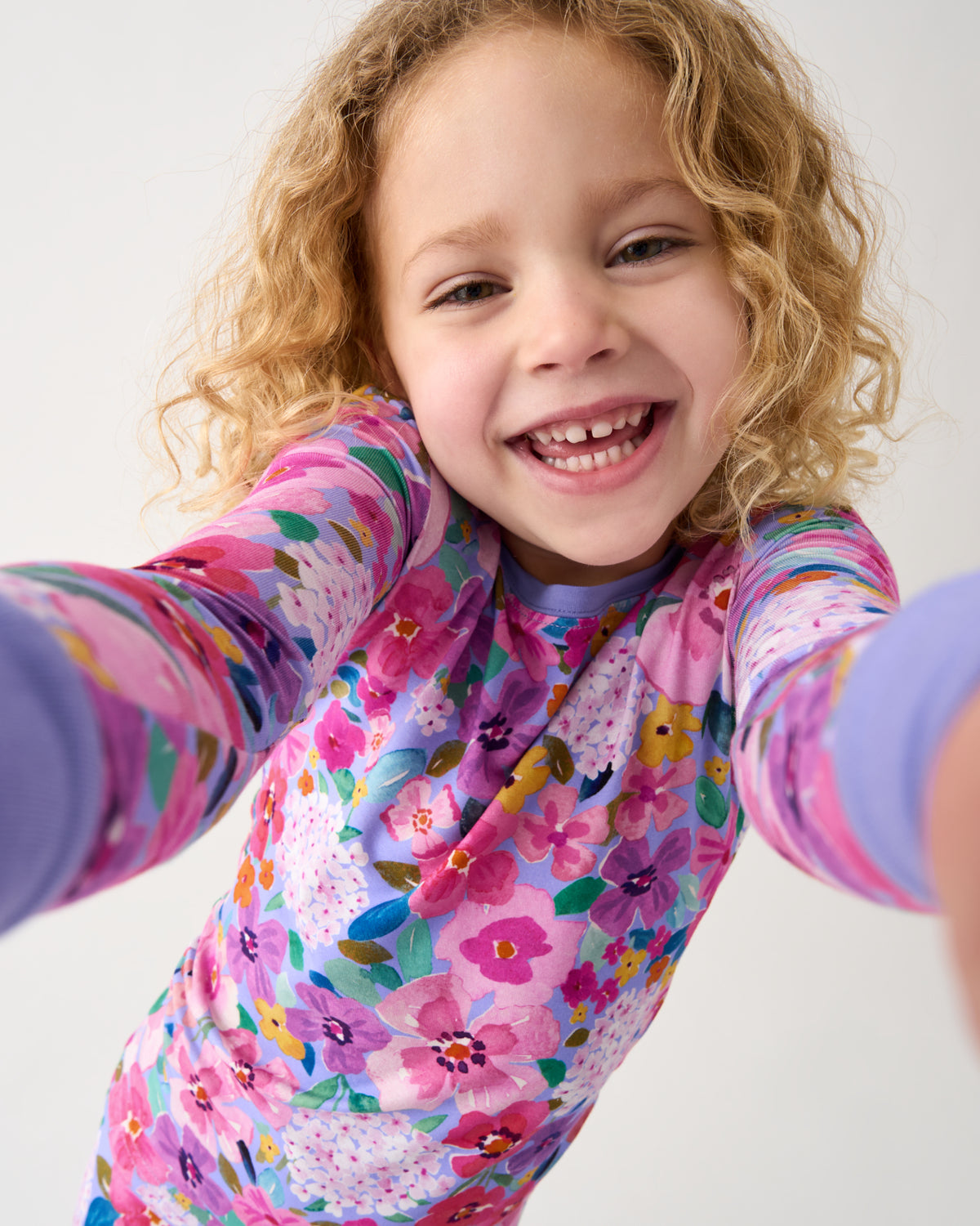 Child wearing the Sweet Sprigs Two-Piece Pajama Set taking a selfie 
