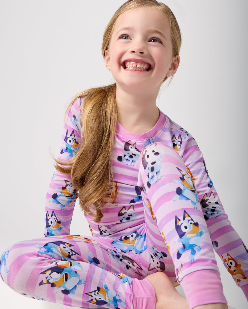 Sitting girl wearing the Pink Bluey Dance All Day Two-Piece Pajama Set