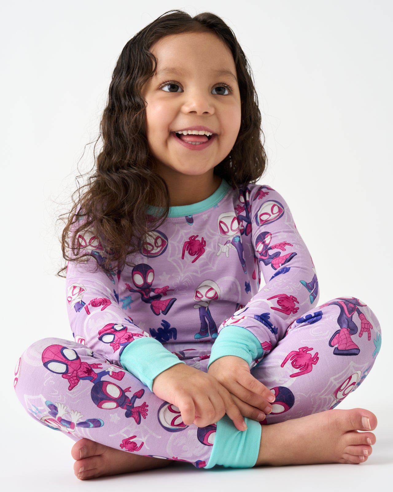 Sitting girl wearing the Spidey & Friends Tiny Webs Two-Piece Pajama Set