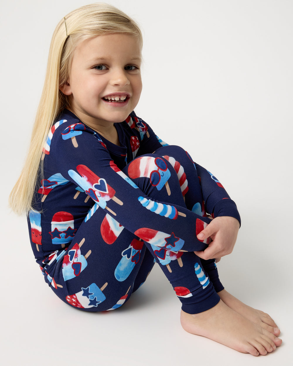 Sitting girl wearing the Sparkle Treats Two-Piece Pajama Set