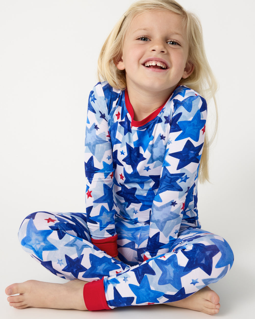 Close up of sitting girl wearing the Starry Splash Two-Piece Pajama Set