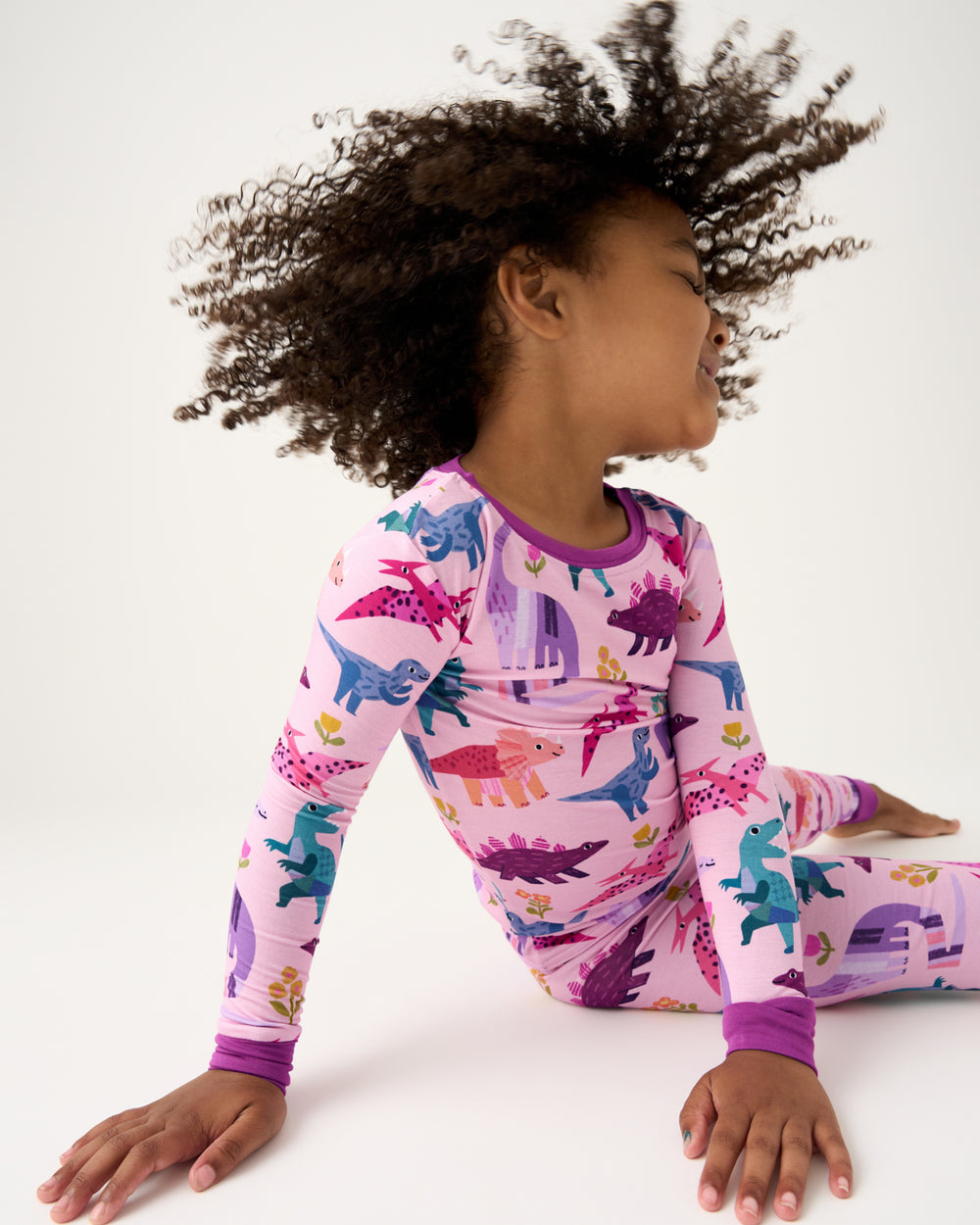 Child in motion wearing the Pink Roar & Explore Two-Piece Pajama Set