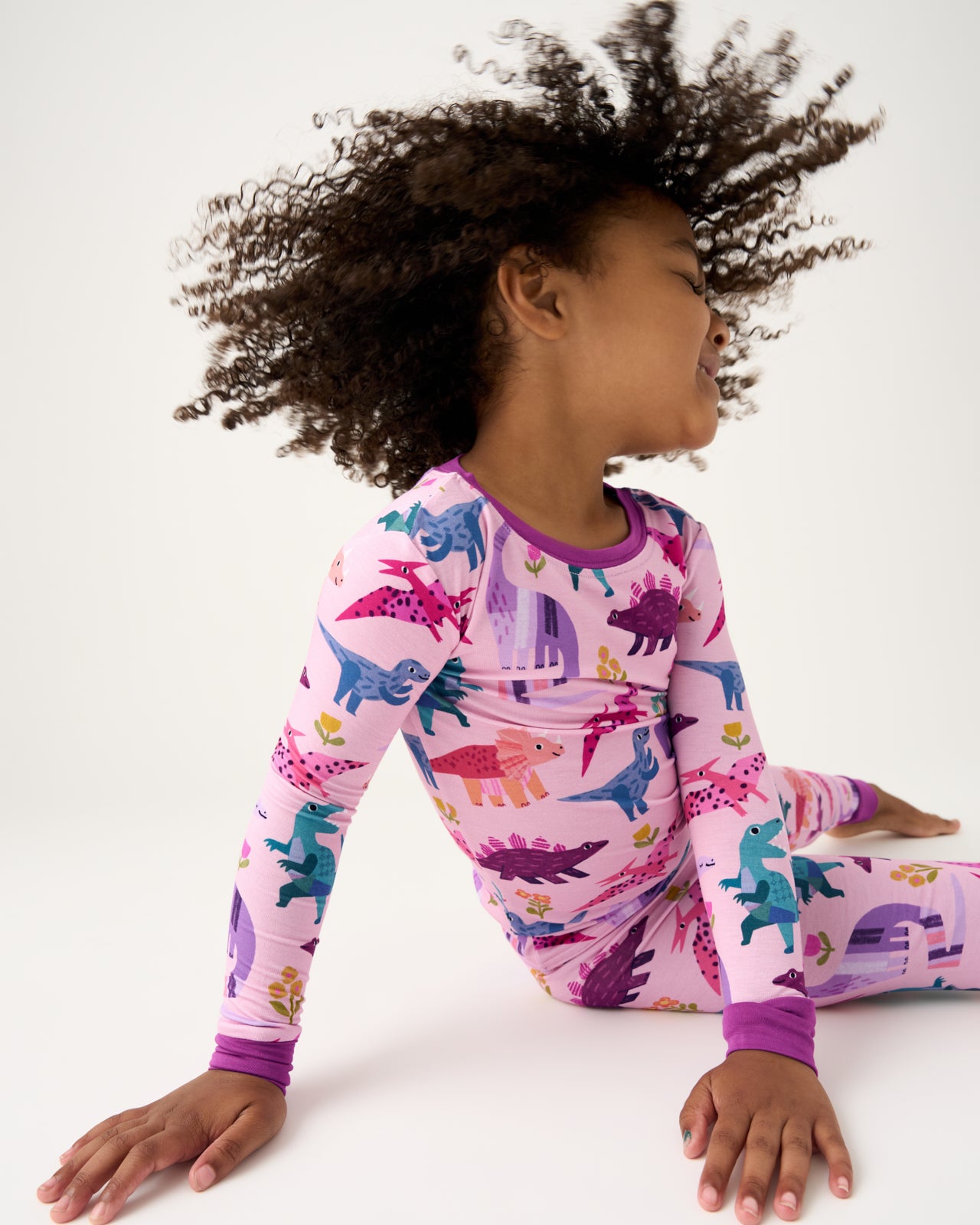 Child in motion wearing the Pink Roar & Explore Two-Piece Pajama Set
