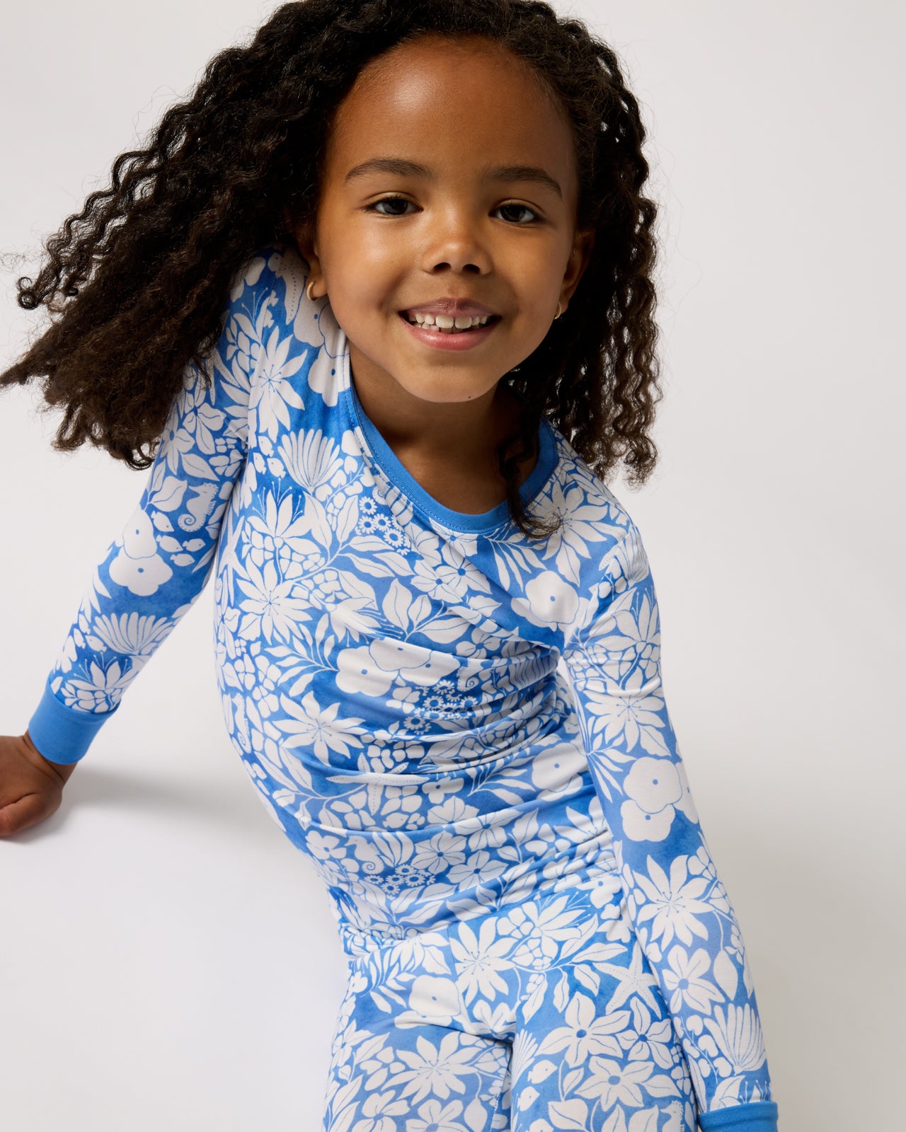 Sitting girl wearing the Azure Garden Two-Piece Pajama Set