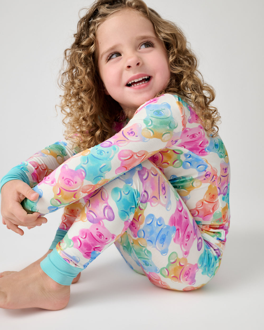Sitting girl wearing the Gummy Giggles Two-Piece Pajama Set