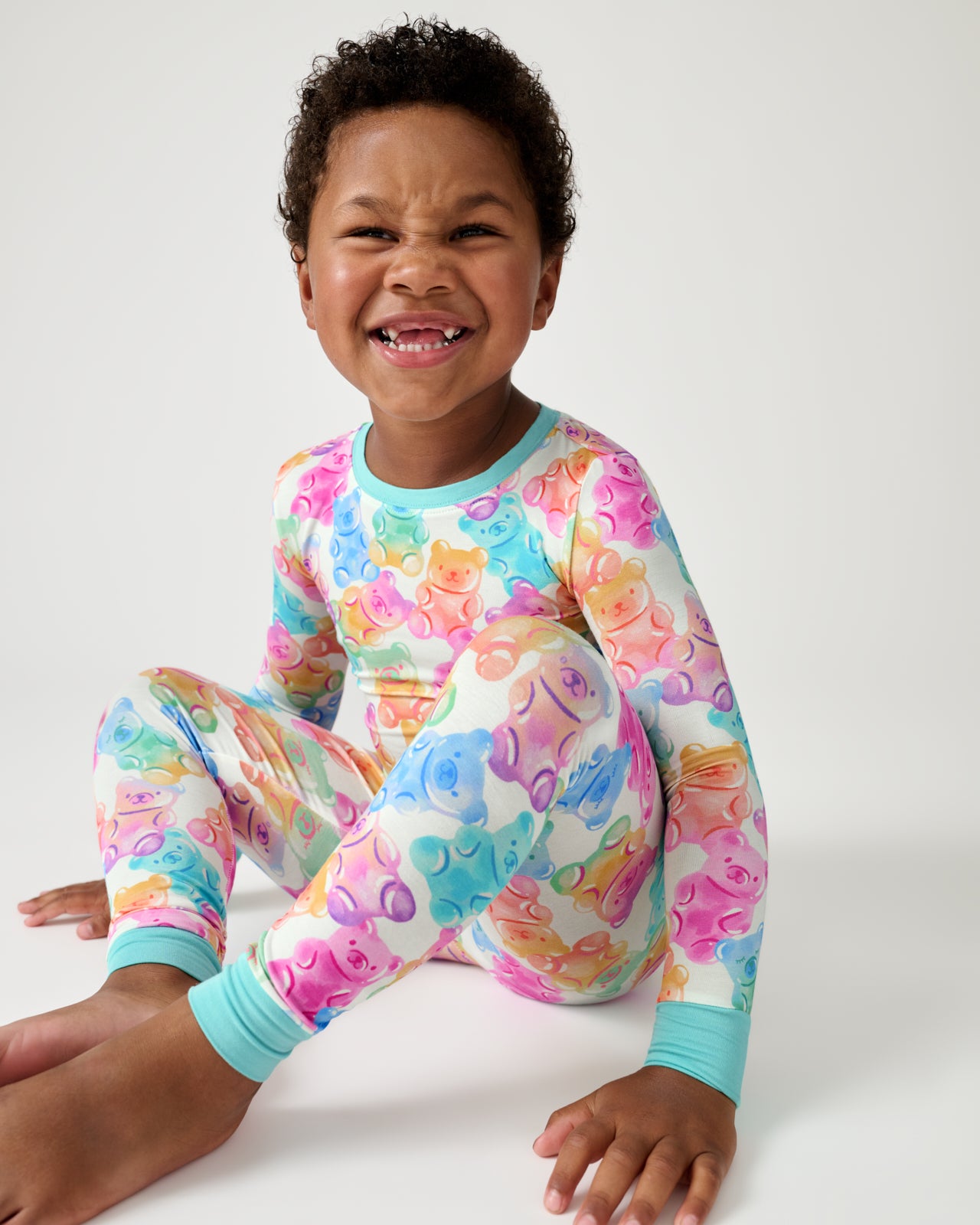 Sitting boy wearing the Gummy Giggles Two-Piece Pajama Set