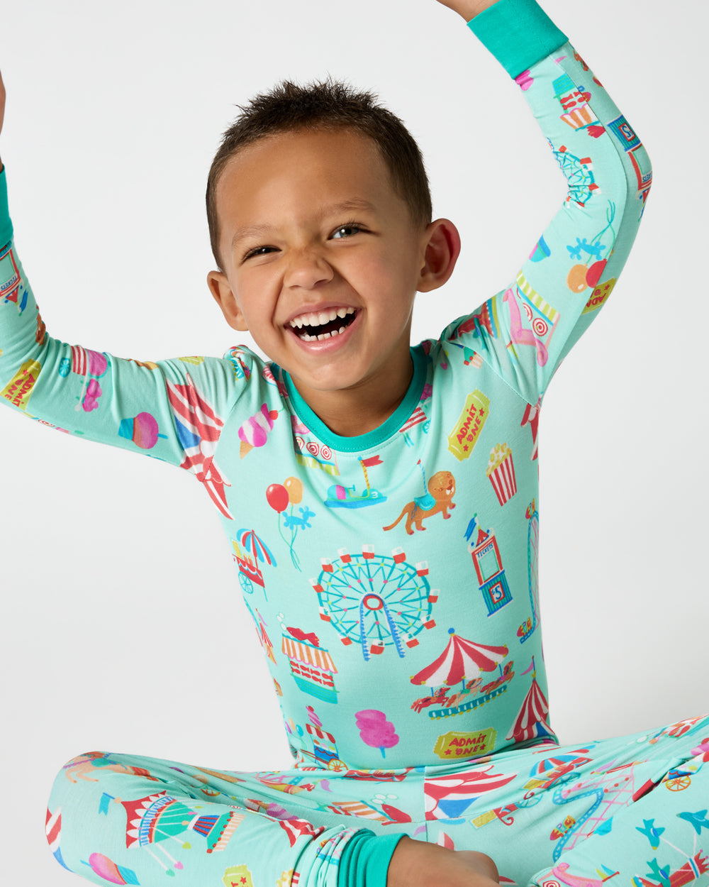 Sitting boy wearing the Fizzy Fair Two-Piece Pajama Set