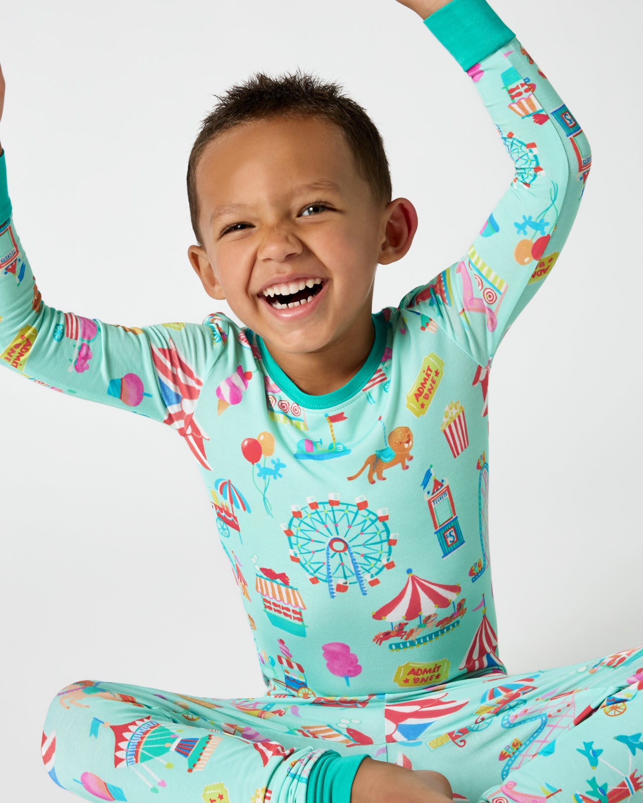 Sitting boy wearing the Fizzy Fair Two-Piece Pajama Set