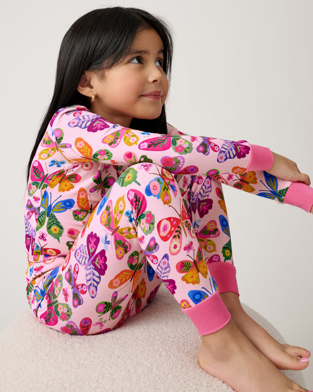 Sitting girl wearing the Flutter Garden Two-Piece Pajama Set