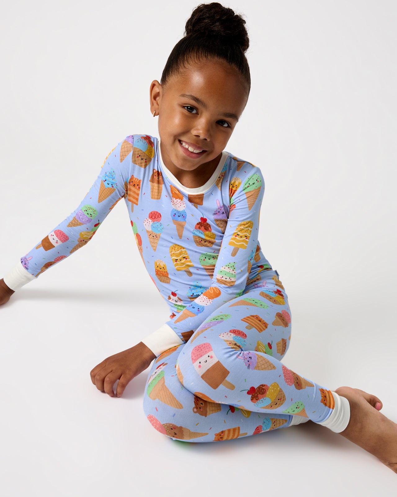 Sitting girl wearing the Scoop Squad Two-Piece Pajama Set