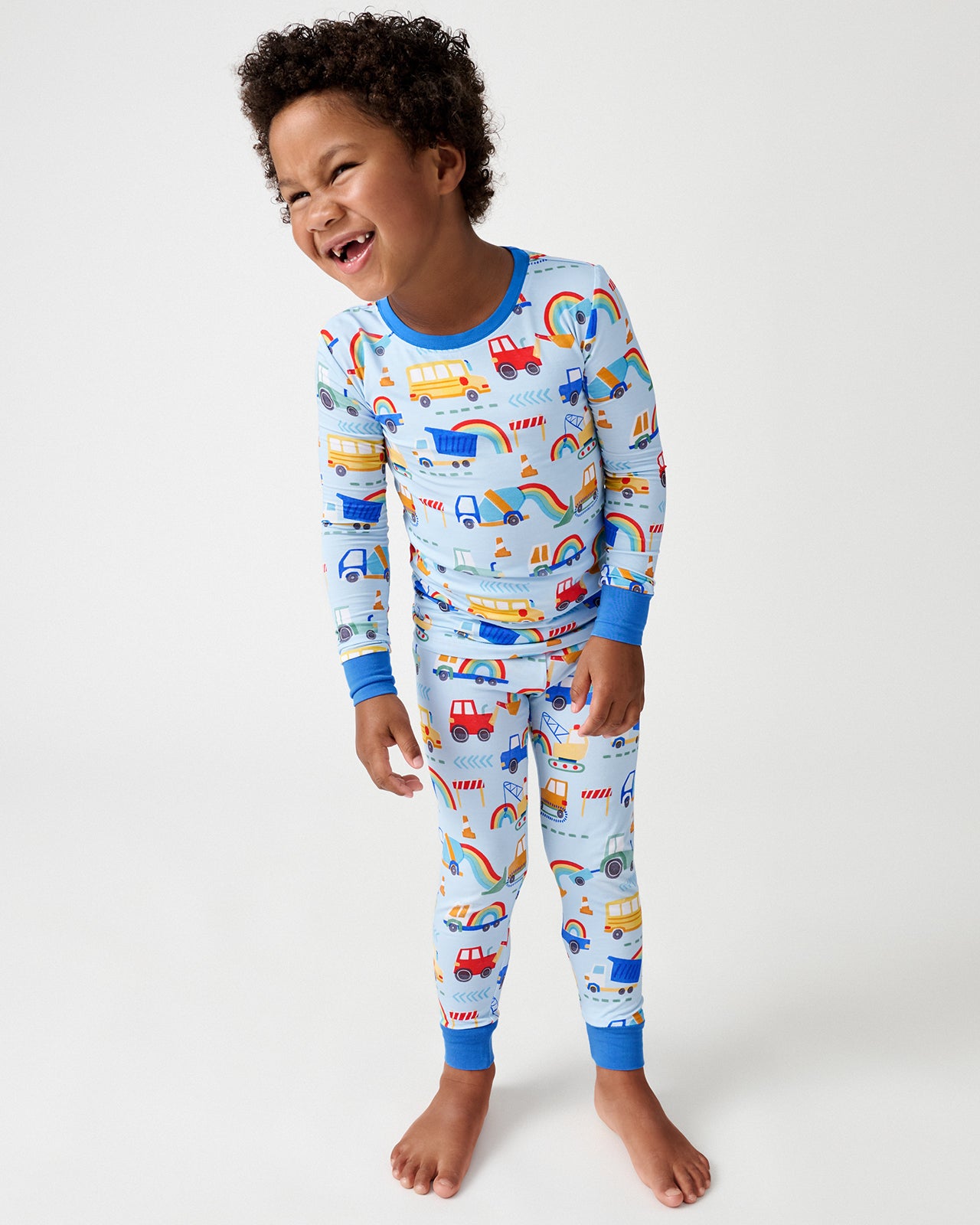 Boy wearing the Rainbow Trucks Two-Piece Pajama Set