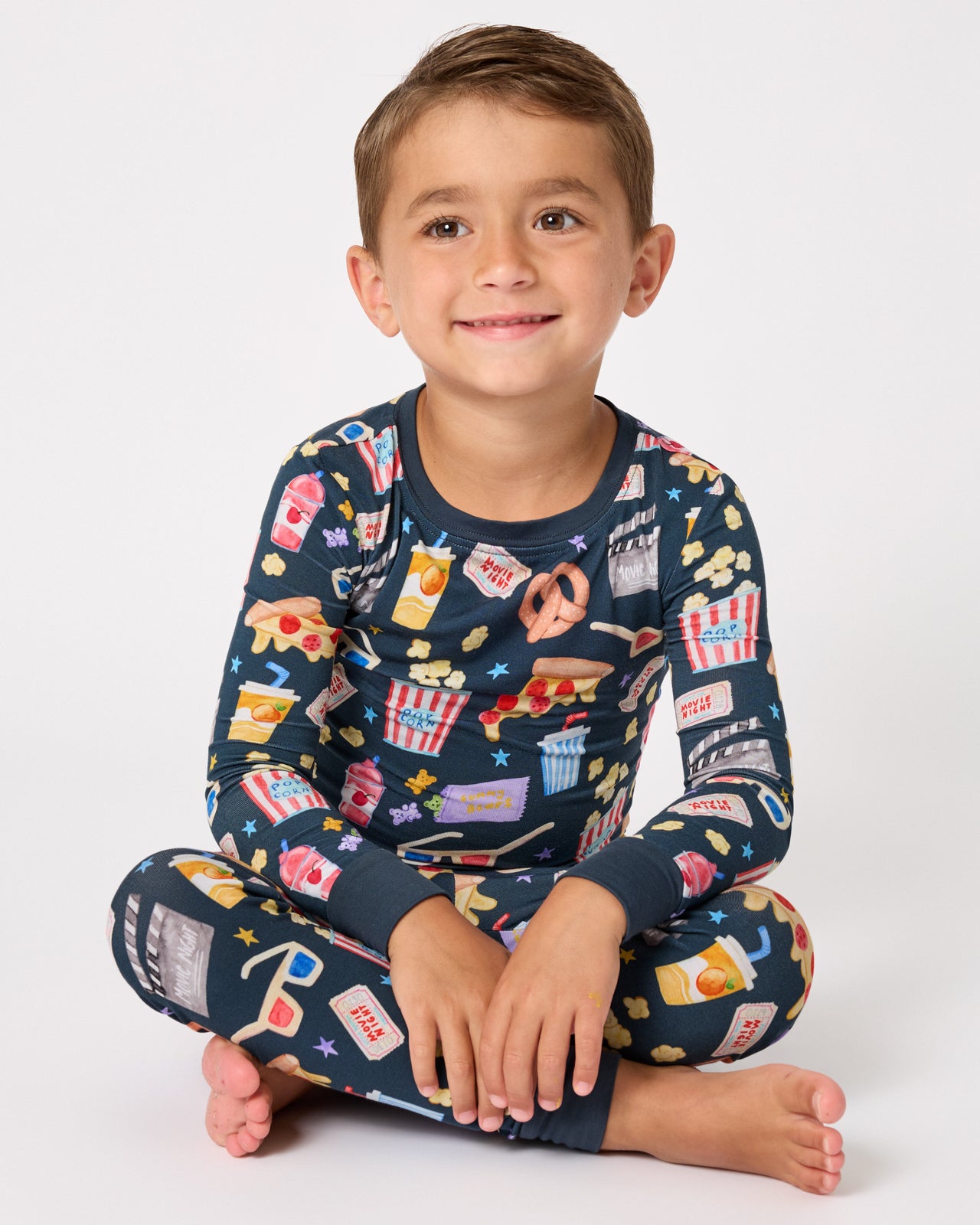 Sitting boy wearing the Movie Marathon Two-Piece Pajama Set