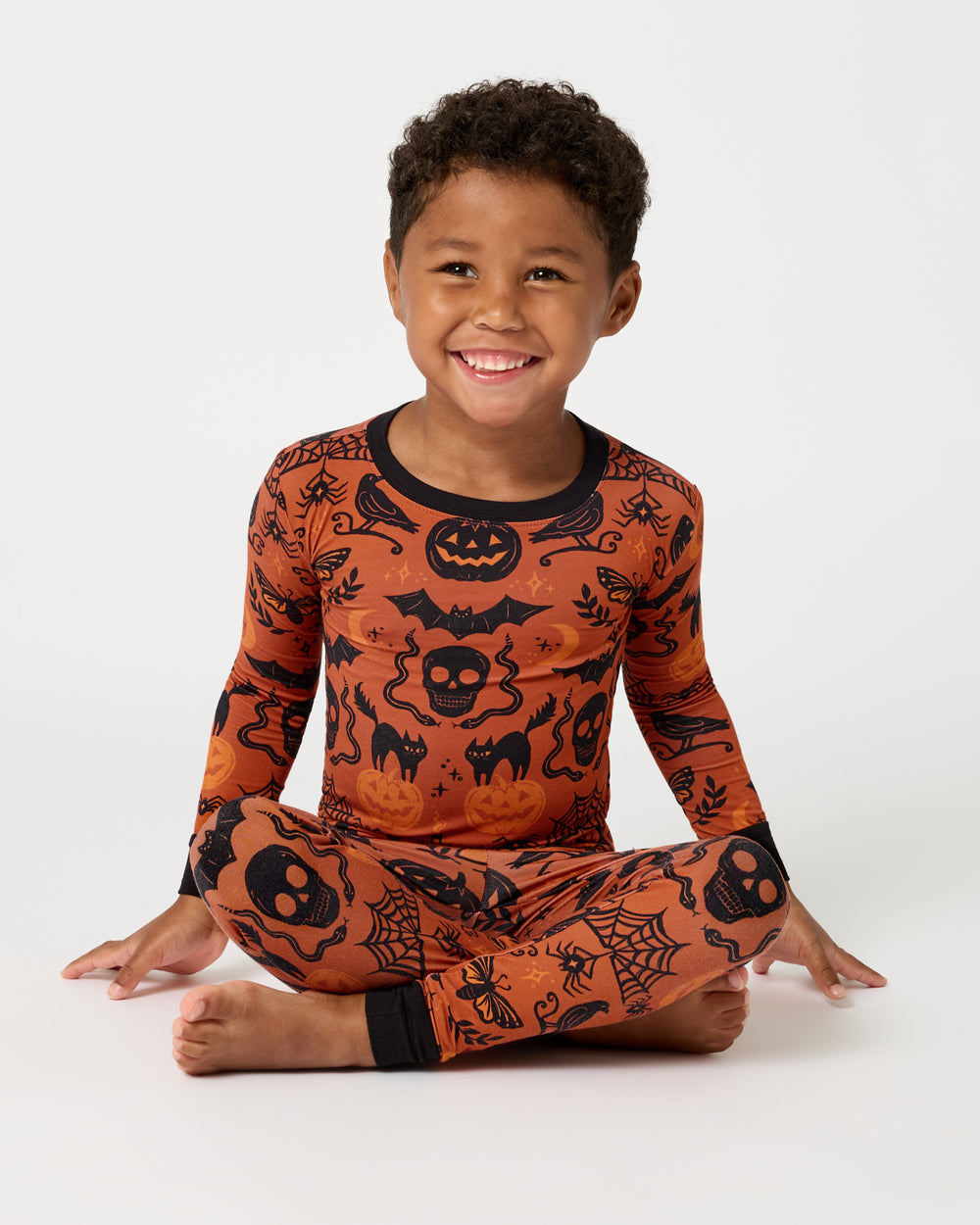 Sitting boy wearing the Midnight Mischief Two-Piece Pajama Set