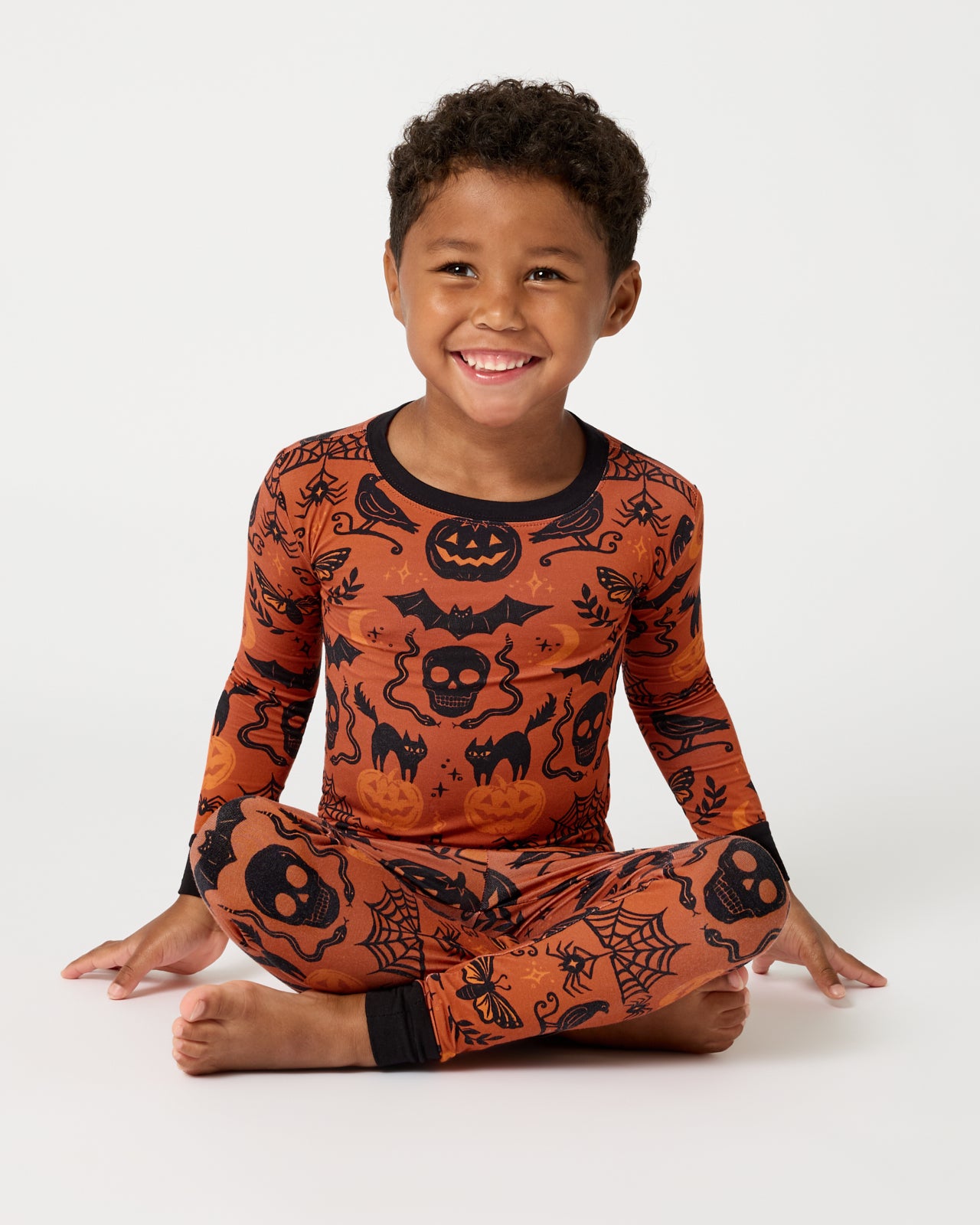 Sitting boy wearing the Midnight Mischief Two-Piece Pajama Set