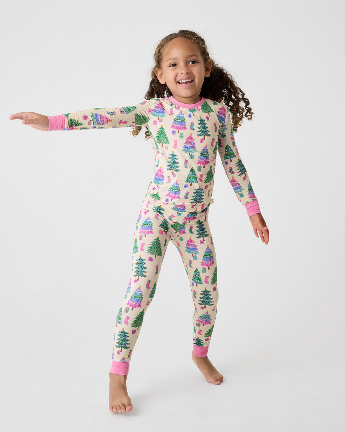 Child in motion wearing the Joyful Traditions Pink Two-Piece Pajama Set