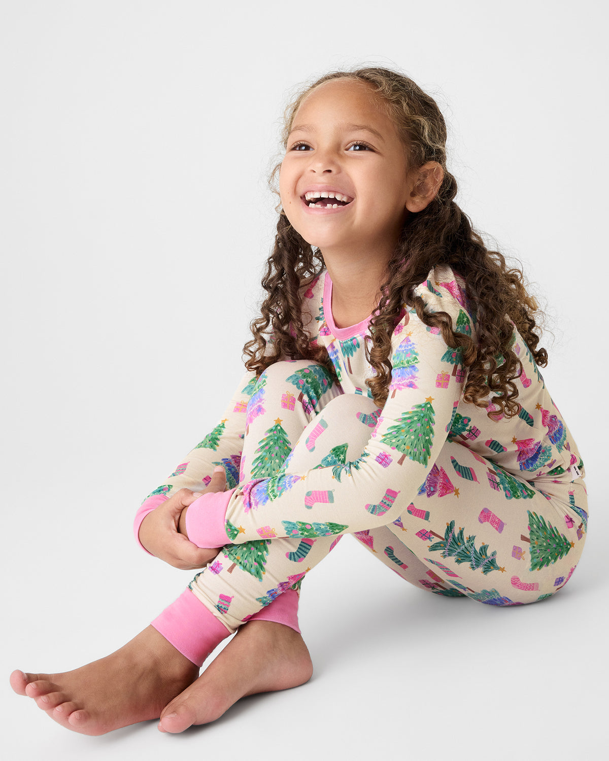Sitting girl wearing the Joyful Traditions Pink Two-Piece Pajama Set