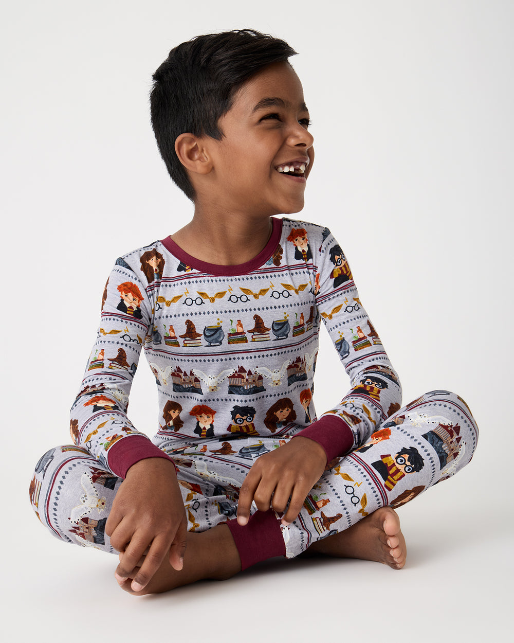 Sitting child wearing the Harry Potter™ Spellbinding Studies Two-Piece Pajama Set
