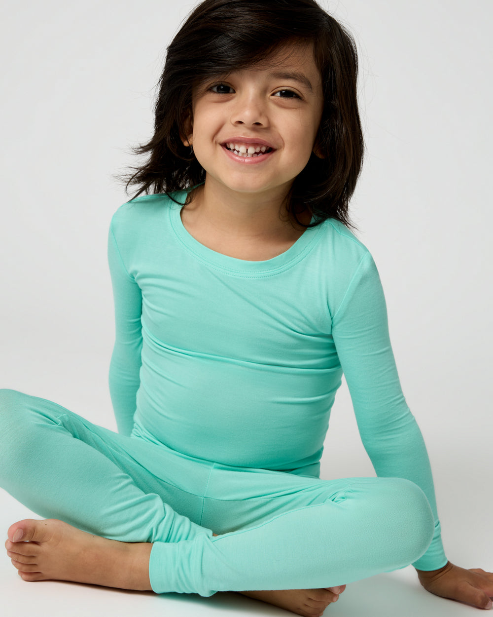 Sitting boy wearing the Ocean Mist Two-Piece Pajama Set