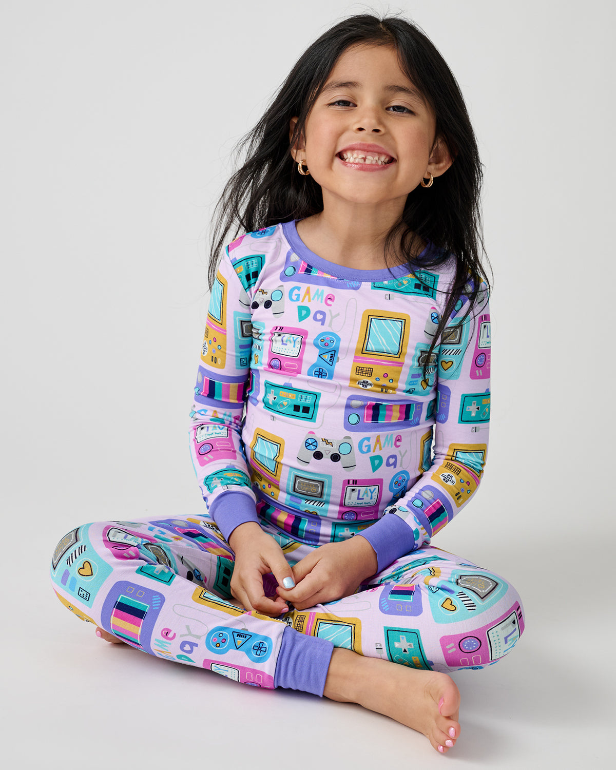 Sitting girl wearing the Purple Game On Two-Piece Pajama Set