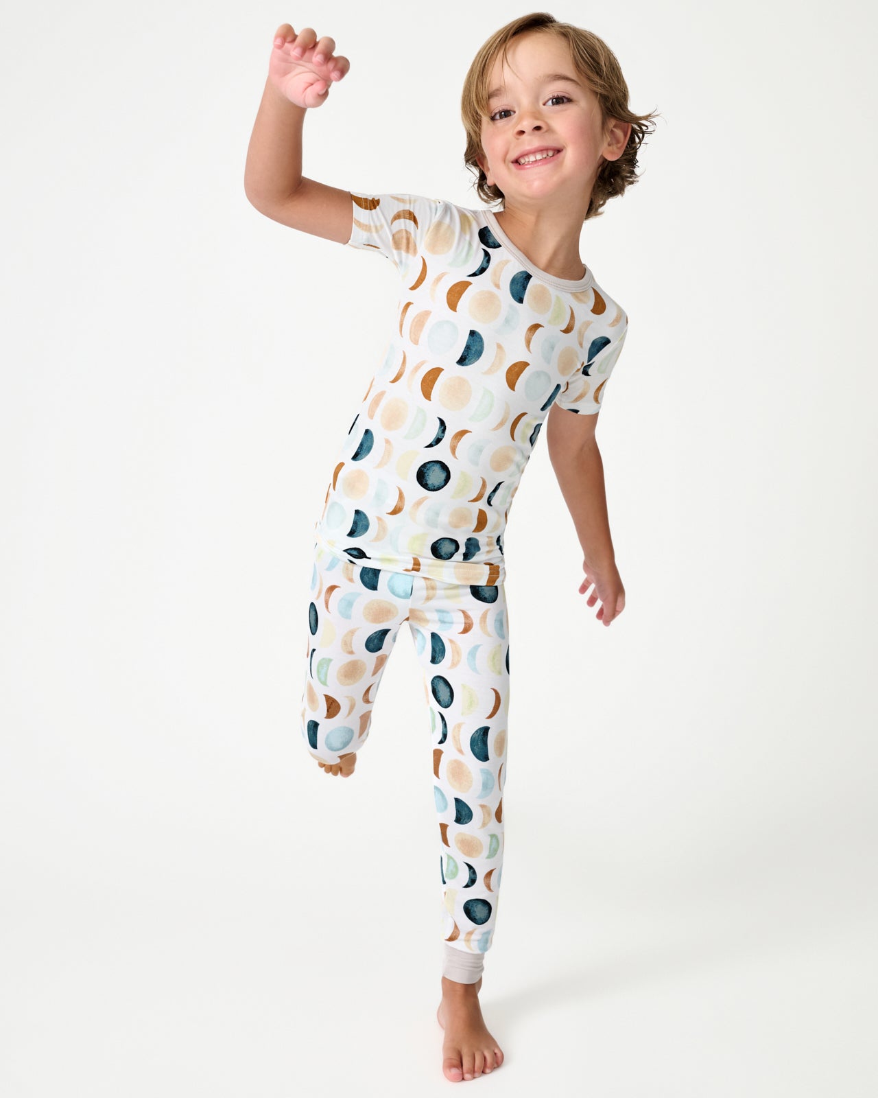 Boy wearing the Luna Neutral Two-Piece Short Sleeve and Pants Pajama Set