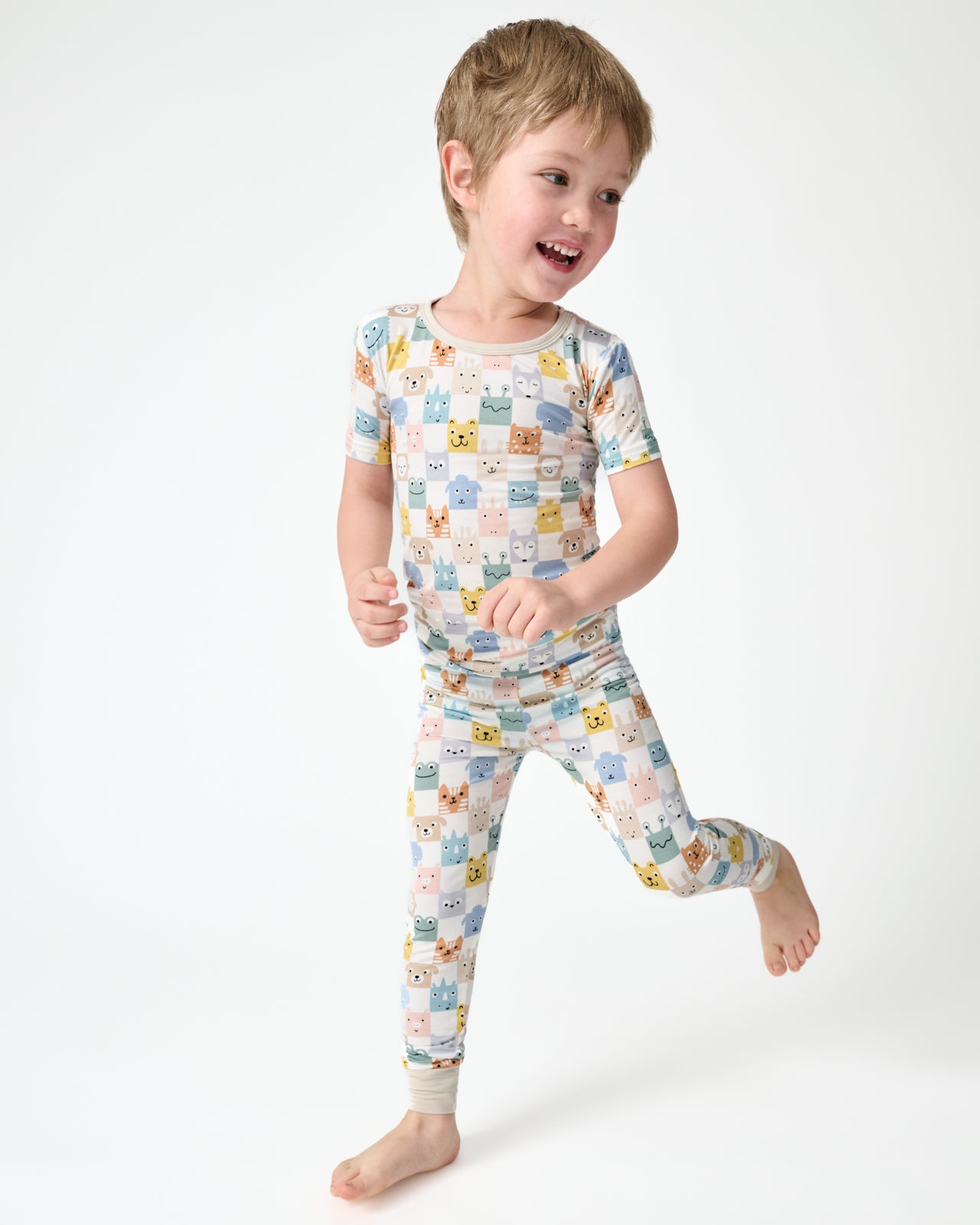 Child in motion wearing the Check Mates Two-Piece Short Sleeve Pajama Set