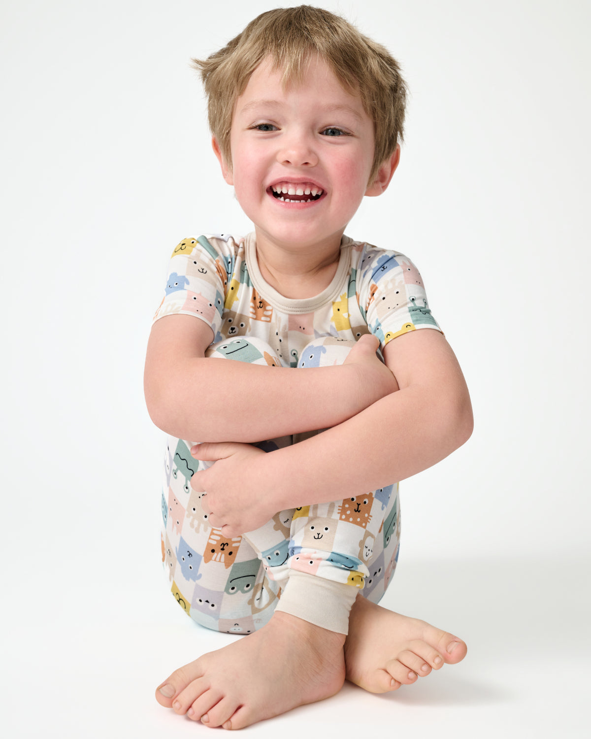 Sitting child wearing the Check Mates Two-Piece Short Sleeve Pajama Set