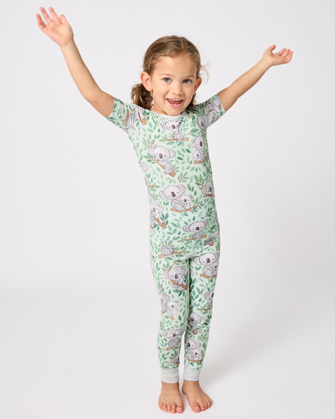 Standing girl wearing the Koala Cuddles Two-Piece Short Sleeve & Pants Pajama Set