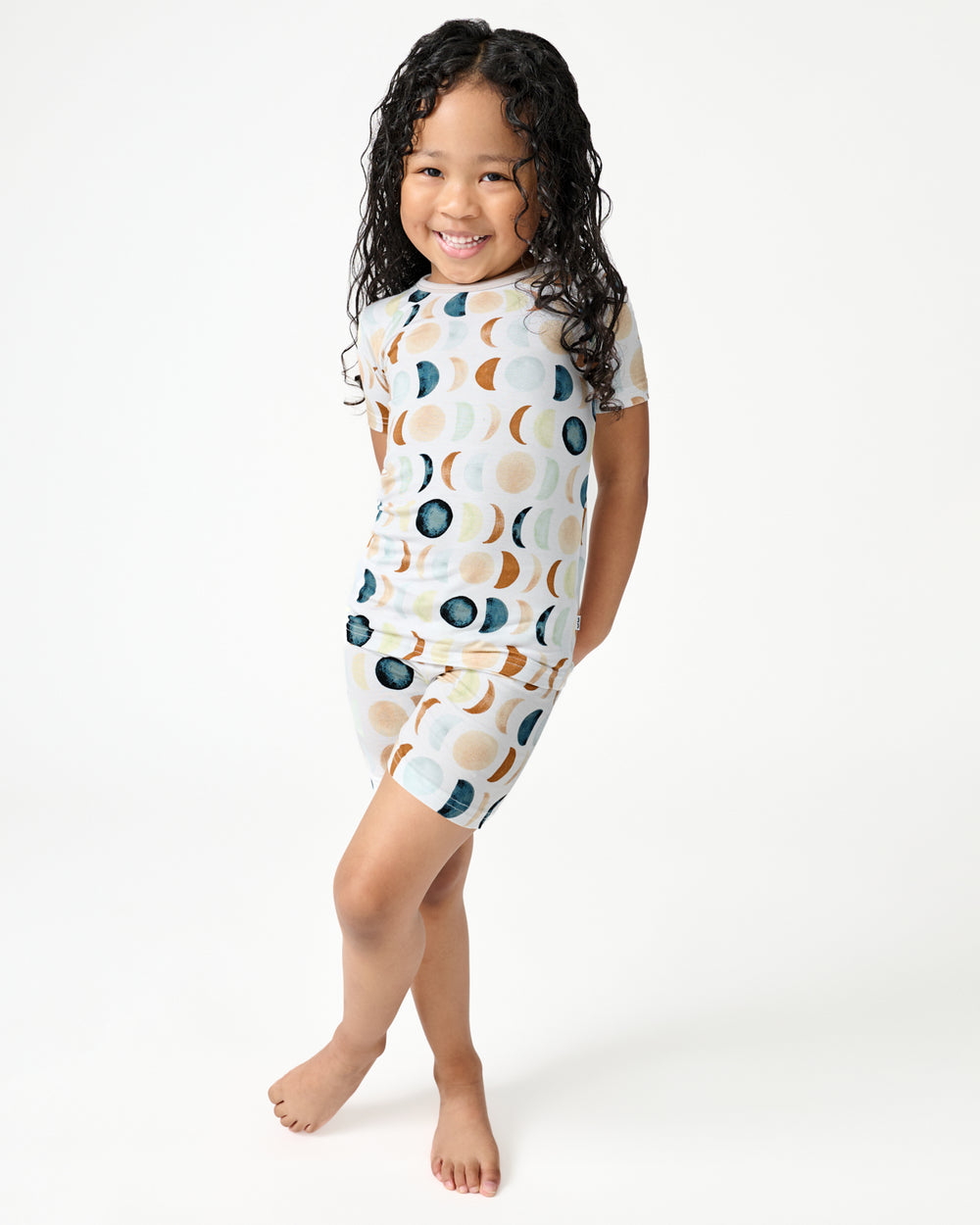 Standing girl wearing the Luna Neutral Two-Piece Short Sleeve & Shorts Pajama Set