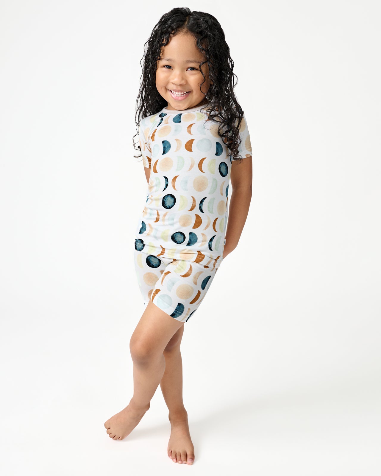 Standing girl wearing the Luna Neutral Two-Piece Short Sleeve & Shorts Pajama Set